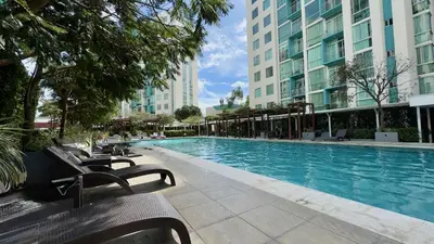 a swimming pool with benches in front of some buildings at Modern, large and equipped in San José