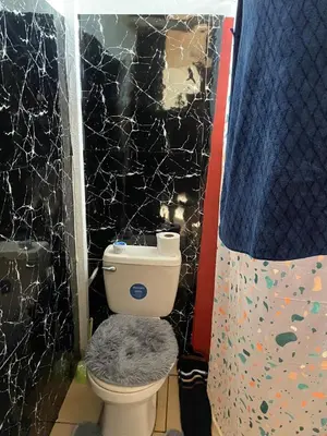 a bathroom with a toilet and a black wall at Casita Campos in Sarapiquí
