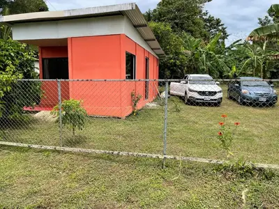 a fence in front of a house with a car at Casita Campos in Sarapiquí