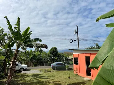 a red building with a car parked next to it at Casita Campos in Sarapiquí