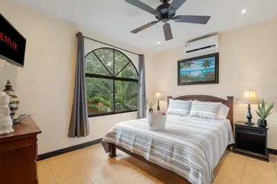 a bedroom with a bed with a ceiling fan at Suite 3 Jaguar - Beach & Pool 2 BR Condo in Brasilito
