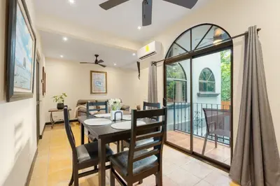 a dining room and living room with a table and chairs at Suite 3 Jaguar - Beach & Pool 2 BR Condo in Brasilito