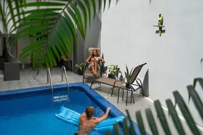 a man in a swimming pool next to a woman at Suite 3 Jaguar - Beach & Pool 2 BR Condo in Brasilito