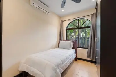 a bedroom with a bed in front of a window at Suite 3 Jaguar - Beach & Pool 2 BR Condo in Brasilito