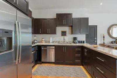 a kitchen with brown cabinets and stainless steel appliances at Suite 4 Sloth - Pool&Beach 3 BR Condo in Brasilito