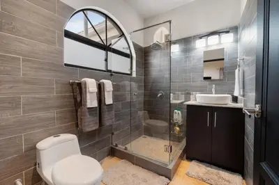 a bathroom with a toilet and a sink and a shower at Suite 4 Sloth - Pool&Beach 3 BR Condo in Brasilito