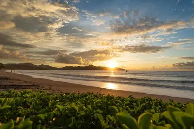 a sunset on a beach with the sun setting at Suite 4 Sloth - Pool&Beach 3 BR Condo in Brasilito