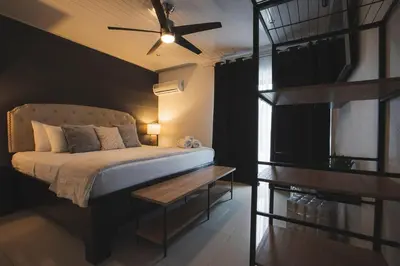 a bedroom with a bed with a ceiling fan at Villa Diriá La Fortuna - Downtown Home in Fortuna