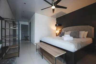 a bedroom with a large bed with a ceiling fan at Villa Diriá La Fortuna - Downtown Home in Fortuna