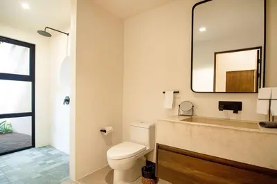 a bathroom with a toilet and a mirror at Rincon Escondido in Nosara