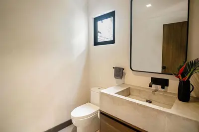 a bathroom with a sink and a toilet and a mirror at Rincon Escondido in Nosara