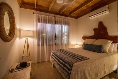 a bedroom with a bed and a mirror and a lamp at Casa Jose in Nosara