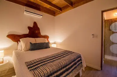 a bedroom with a bed with a wooden headboard at Casa Jose in Nosara