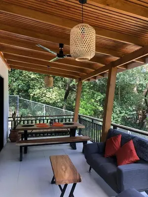 a patio with a couch and a table and a ceiling at Casa Manzu in Nosara