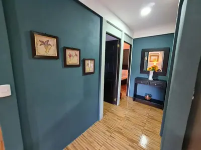 a hallway with a blue wall with pictures on it at Casa del Sol Playa Avellanas in San José Pinilla