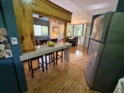 a kitchen and living room with a refrigerator and a table at Casa del Sol Playa Avellanas in San José Pinilla