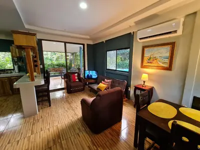 a living room with couches and a table and chairs at Casa del Sol Playa Avellanas in San José Pinilla