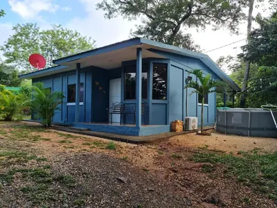 a blue tiny house with a porch at Casa del Sol Playa Avellanas in San José Pinilla