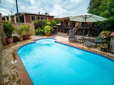 a large blue swimming pool in front of a house at Hotel Mar y Mar in Puntarenas