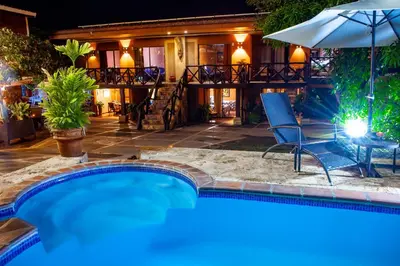 a pool with a table and chairs and an umbrella at Hotel Mar y Mar in Puntarenas