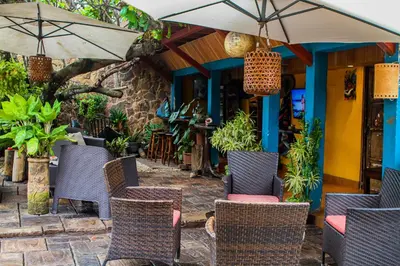 an outdoor patio with chairs and an umbrella at Hotel Mar y Mar in Puntarenas