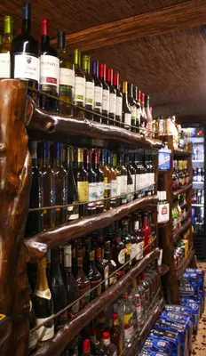 a store shelf filled with lots of bottles of wine at Hotel Mar y Mar in Puntarenas