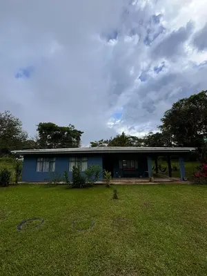 a blue house with a yard in front of it at Finca Marbella in San Ramón