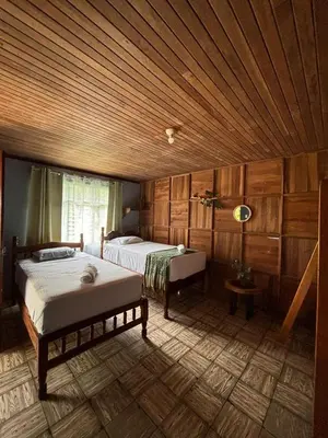 a bedroom with two beds and a wooden ceiling at Finca Marbella in San Ramón