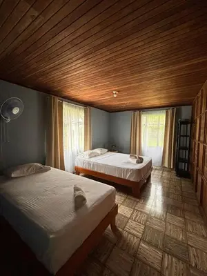 a bedroom with two beds and a wooden ceiling at Finca Marbella in San Ramón