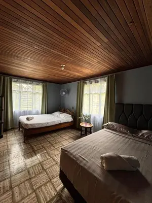 a bedroom with a large bed and a wooden ceiling at Finca Marbella in San Ramón