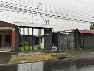 a building with a gate on the side of a street at Perezoso View Apartment in Guápiles