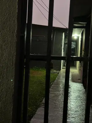 a view of an alley at night through a fence at Perezoso View Apartment in Guápiles