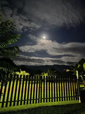 a fence with the moon in the sky at Cabinas MaWa Tropical 5 minutos a playa in Uvita