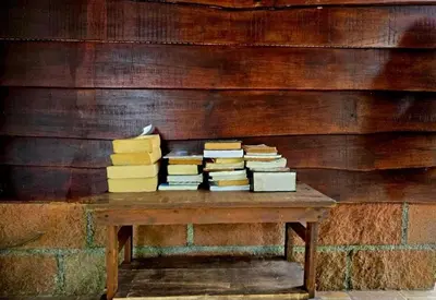 a pile of books sitting on a wooden table at Cabinas MaWa Tropical 5 minutos a playa in Uvita