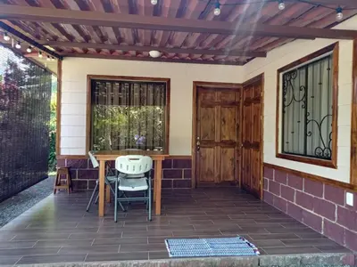 a patio with a wooden door and a table and chairs at Cabinas MaWa Tropical 5 minutos a playa in Uvita