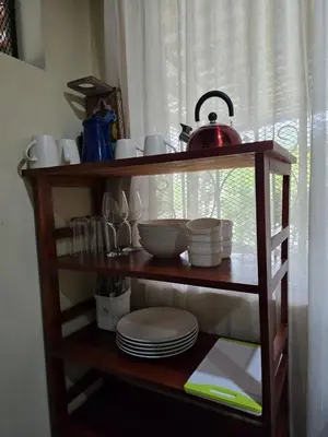 a shelf with dishes and a tea kettle on it at Cabinas MaWa Tropical 5 minutos a playa in Uvita