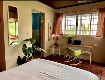 a bedroom with a bed and a desk and chairs at Mi Zaru Sea View Hotel Free Park Tour & Breakfast in Manuel Antonio