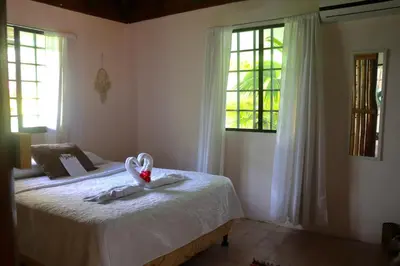 a bedroom with a bed with a flower on it at Mi Zaru Sea View Hotel Free Park Tour & Breakfast in Manuel Antonio