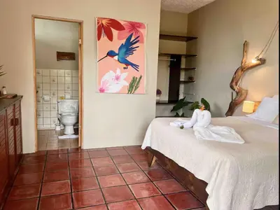 a bedroom with a bed with a towel on it at Mi Zaru Sea View Hotel Free Park Tour & Breakfast in Manuel Antonio