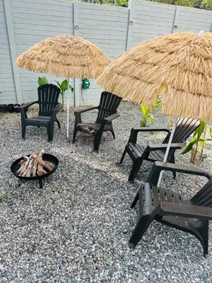 a fire pit and two chairs and umbrellas at House with a private swimming pool in Chontales