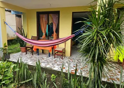 a hammock in front of a house at Cabinas Miss Miriam 2 in Tortuguero