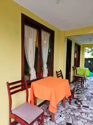a dining room with an orange table and chairs at Cabinas Miss Miriam 2 in Tortuguero