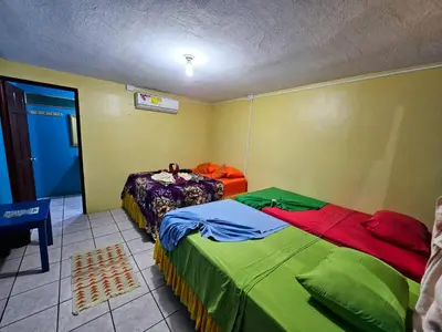 a room with two beds and a table in it at Cabinas Miss Miriam 2 in Tortuguero