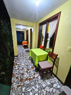a patio with a green table and chairs in a room at Cabinas Miss Miriam 2 in Tortuguero