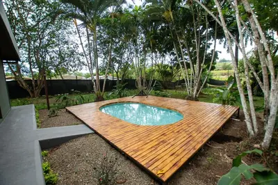 a wooden deck with a swimming pool in a garden at Casa del Lago in Repunta