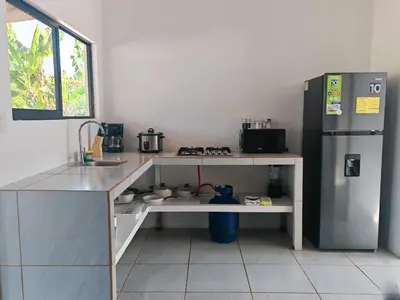 a kitchen with a sink and a refrigerator at Casa Celeste Rio Grande #2 in Puntarenas
