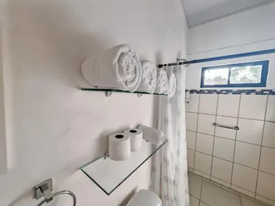 a bathroom with a toilet and towels on a wall at Casa Celeste Rio Grande #2 in Puntarenas