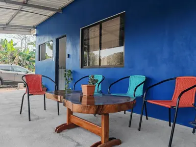 a table and chairs in front of a blue wall at Casa Celeste Rio Grande #2 in Puntarenas