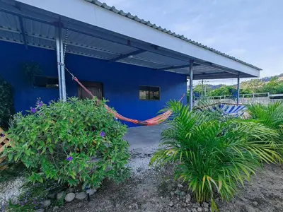 a blue building with a hammock in front of it at Casa Celeste Rio Grande #2 in Puntarenas