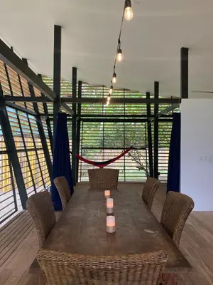 a dining room with a wooden table and chairs at Awarded No Footprint House on Matapalo Beach in Savegre
